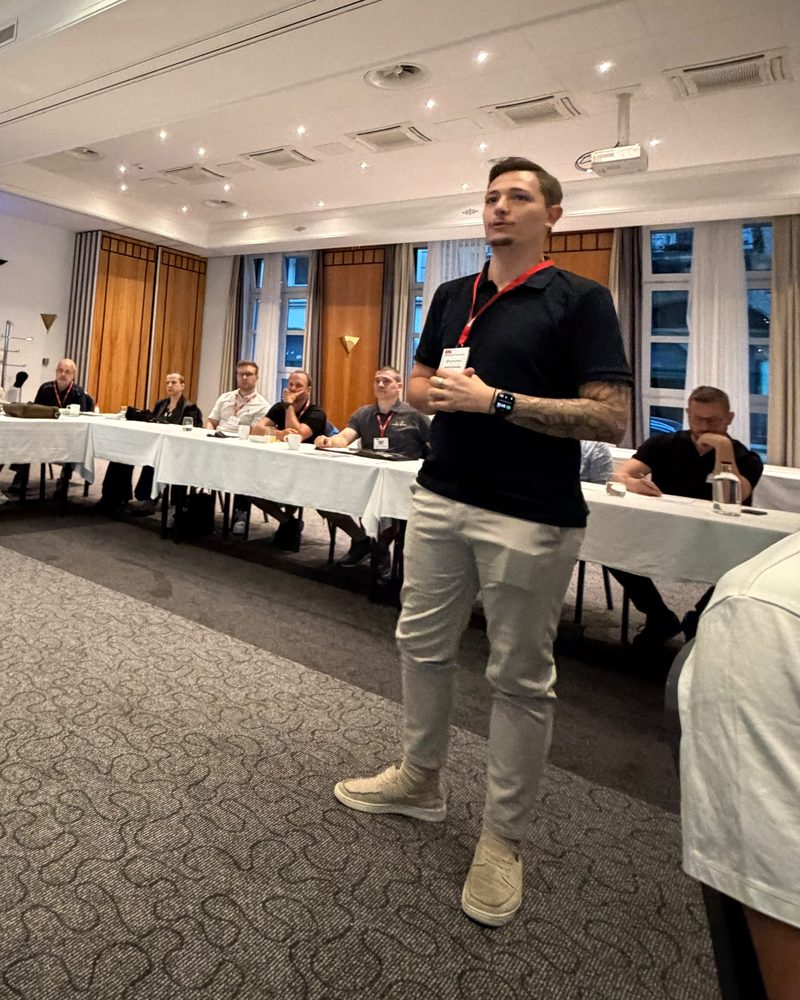 Roberto Stambolija steht vor einer Runde von Unternehmerinnen und Unternehmern und spricht
